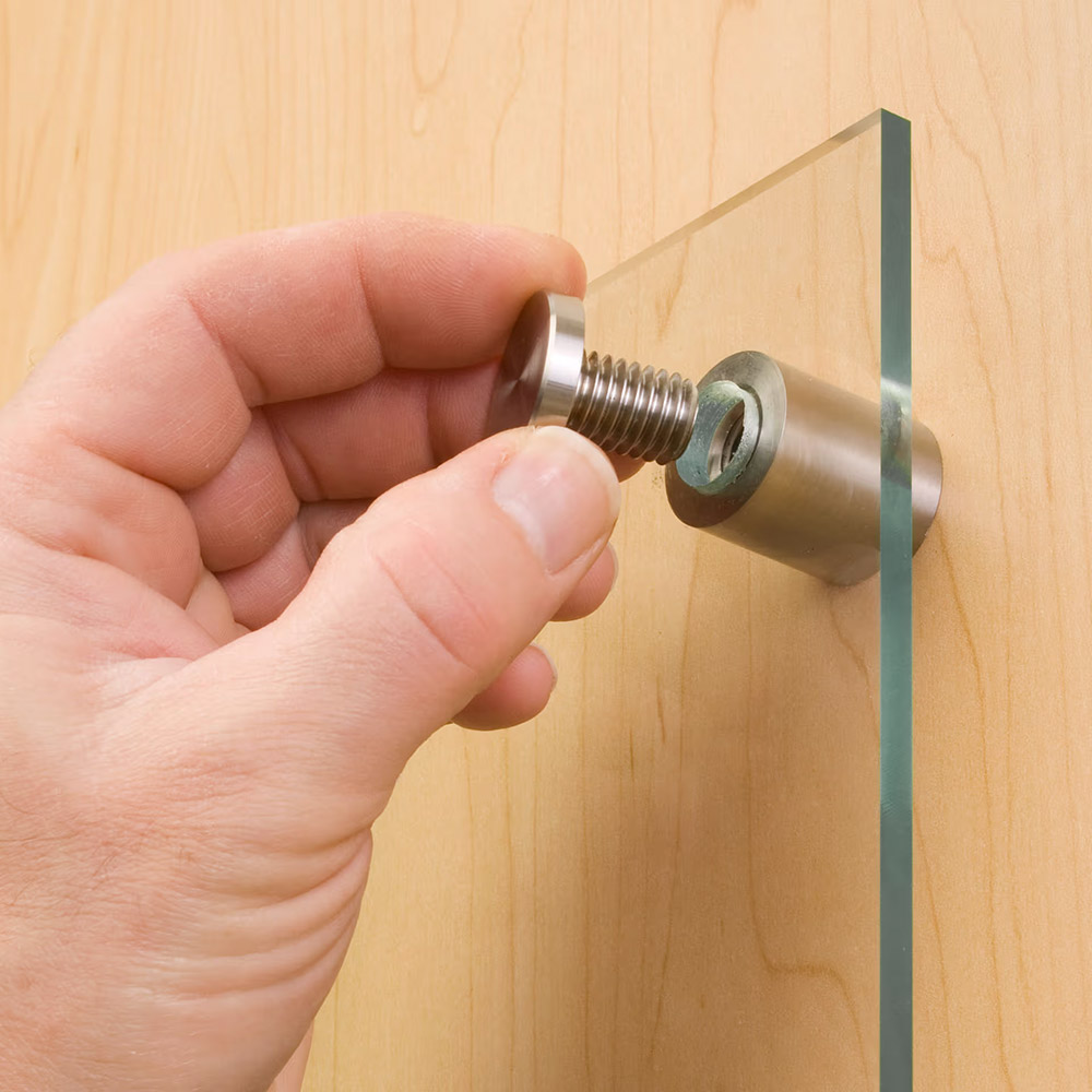 Hand installing acrylic print with standoff hardware